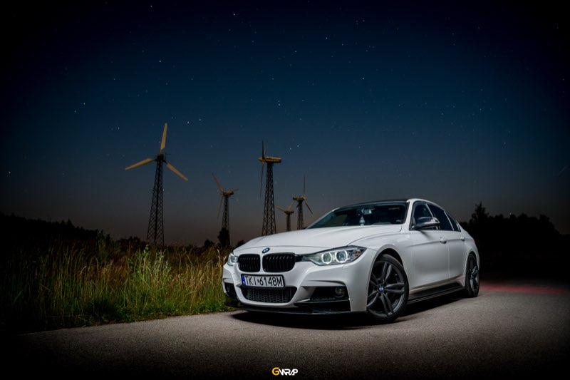 Biale BMW serii 3 F30 po profesjonalnym detailingu - sesja nocna przy turbinach wiatrowych, studio GWrap okolice Kielc