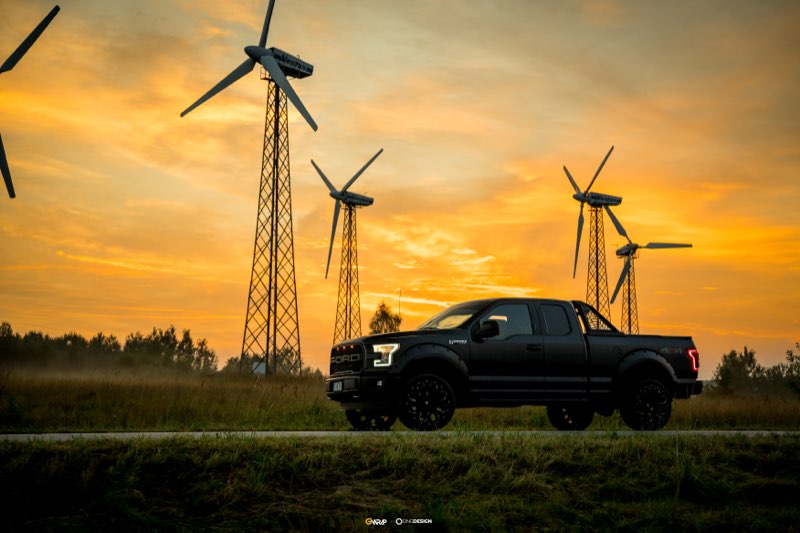 Czarny Ford F-150 Raptor po autodetailingu na tle turbin wiatrowych o zachodzie slonca - realizacja GWrap Kielce