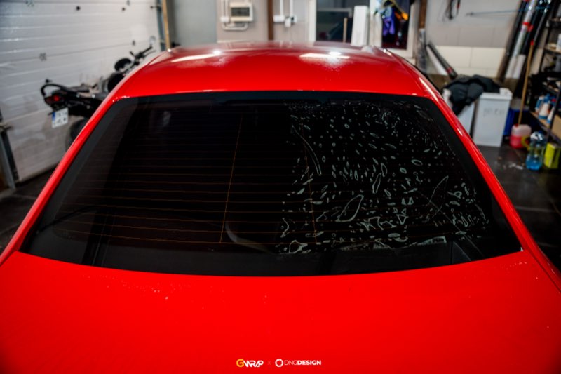 Przyciemnianie tylnej szyby czerwonego Audi A3 w trakcie aplikacji folii - studio GWrap, Przyjmo k. Kielc