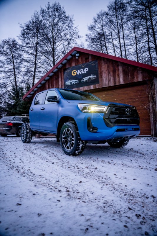 Niebieska Toyota Hilux po oklejeniu folia - zmiana koloru auta przed siedziba studia GWrap w Przyjmo kolo Kielc, zima
